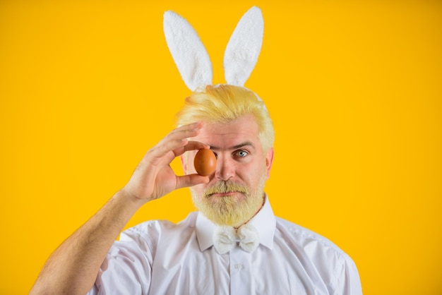 Happy easter man with rabbit ears holds easter egg man in bunny ears holds easter egg rabbit man