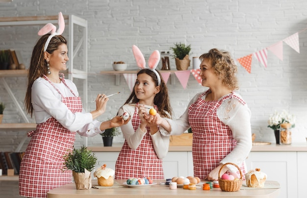 Happy Easter Mother and daughters draw Easter eggs A happy family is preparing for Easter