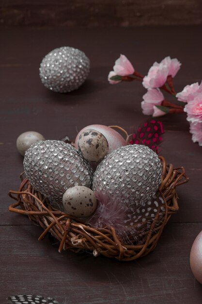 Happy Easter nest with eggs on a wooden background Happy Easter greeting card with creative easter eggs and blossom cherry