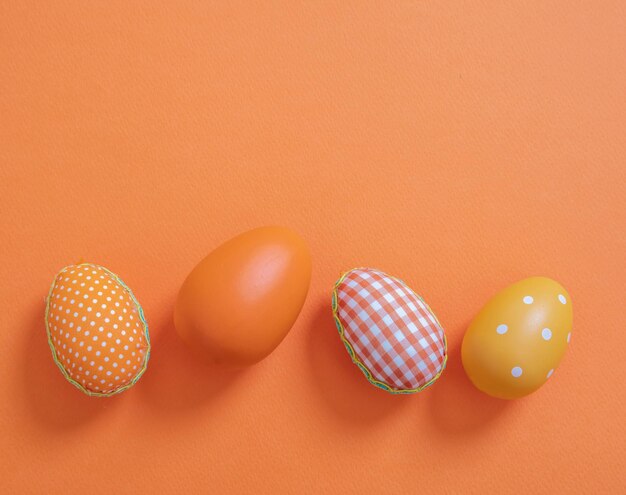 Happy Easter Orange pastel color eggs on orange background copy space