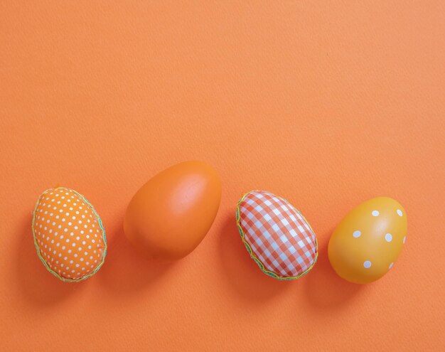 Happy easter orange pastel color eggs on orange background copy space