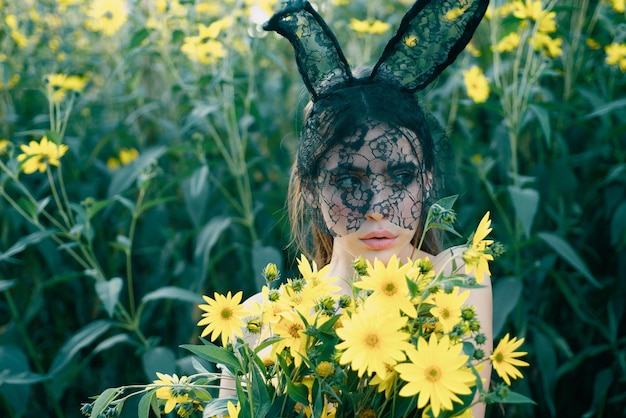 Happy easter spring bunny woman with flowers rabbit girl outside bouquet of flowers