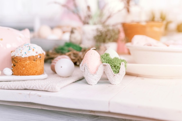 Happy easter and spring holidays time festive tablescape set decor traditional dinner food easter eggs and baked cakes on table at home rabbit and willow pale pop pastel blue and pink color flare