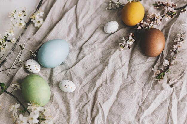 Happy Easter Stylish Easter eggs and cherry blossoms on rustic linen cloth