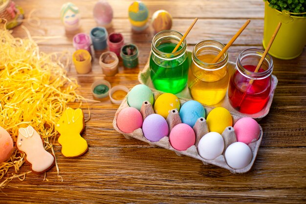 Happy Easter with colorful eggs in basket. Table decorating for holiday. Top view.