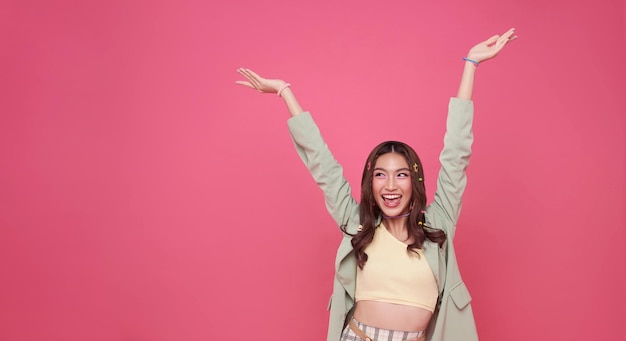 Happy ecstatic cheerful asian woman fist up raise win gesture isolated on pink copy space background