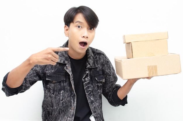 흰색 배경 위에 고립 된 패키지 소포 상자를 들고 행복 황홀 젊은 아시아 남자