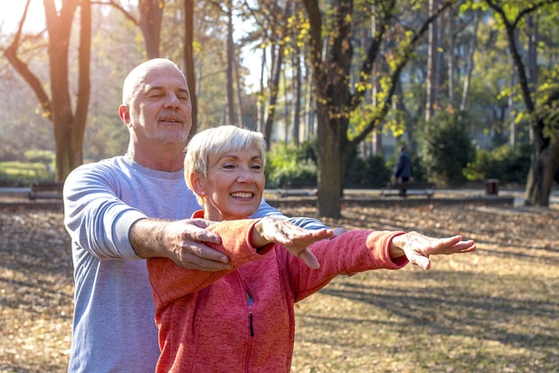 Happy elder couple exercising in a park