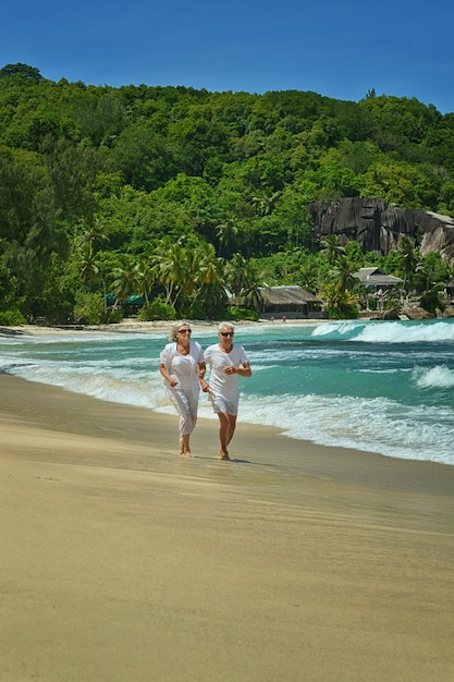 Happy elderly couple running on a beach