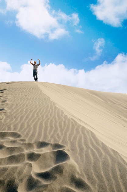 Happy elderly man standing on the white sand