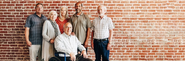 Photo happy elderly man on a wheelchair with friends