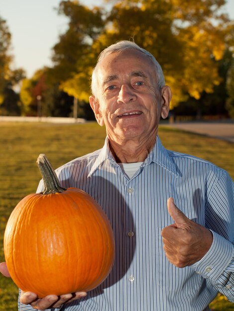 Happy elderly man with pumpkins.