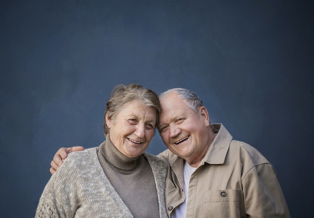 Happy elderly married couple on blue background