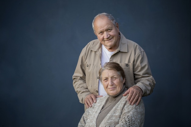 Happy elderly married couple on blue background
