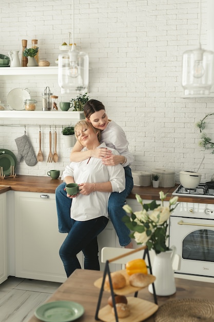 Happy elderly mother and daughter in the kitchen