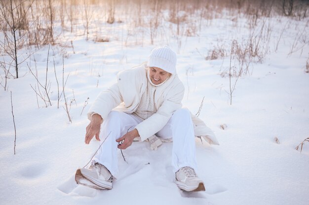 Happy elderly senior mature woman in white warm outwear