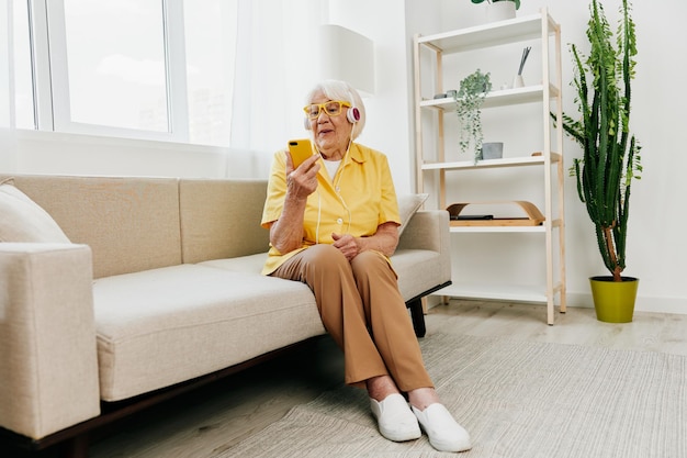 Photo happy elderly woman looking into phone video call smile technology for communication bright modern interior lifestyle online communication