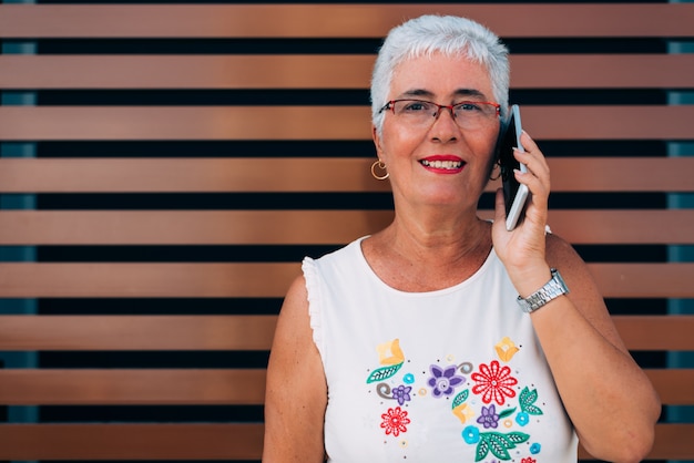 Happy elderly woman on the mobile phone