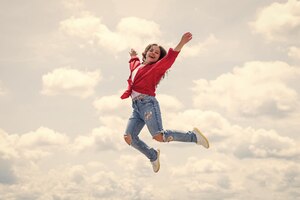 Фото Счастливый энергичный ребенок чувствует себя свободным и прыгает с высокой свободой