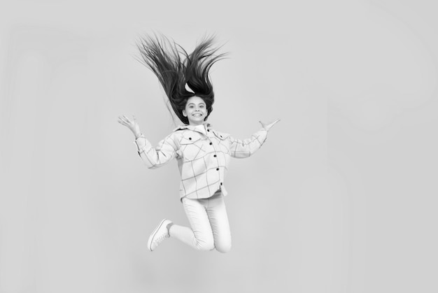 Happy energetic teen girl jump in pink checkered shirt freedom