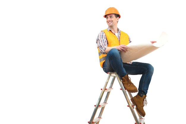 The happy engineer with a paper sitting on the ladder on the white background