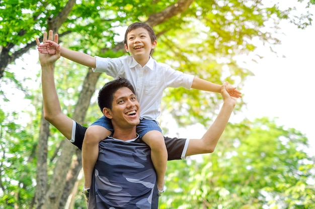 アジアを幸せに楽しんでください。夏の公園で楽しんでいる父と息子