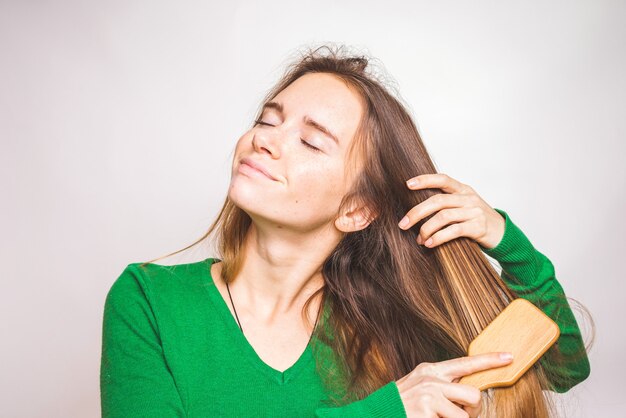 幸せな楽しみの女の子は、健康な光沢のある美しい髪を分離します