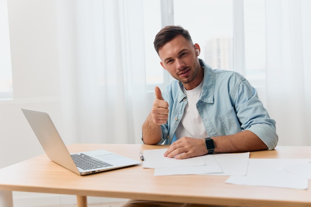 Happy enthusiastic smiling nicelooking young businessman show\
thumb up gesture like in office communicates with candidate copy\
space for ad remote job technology and career profession\
concept