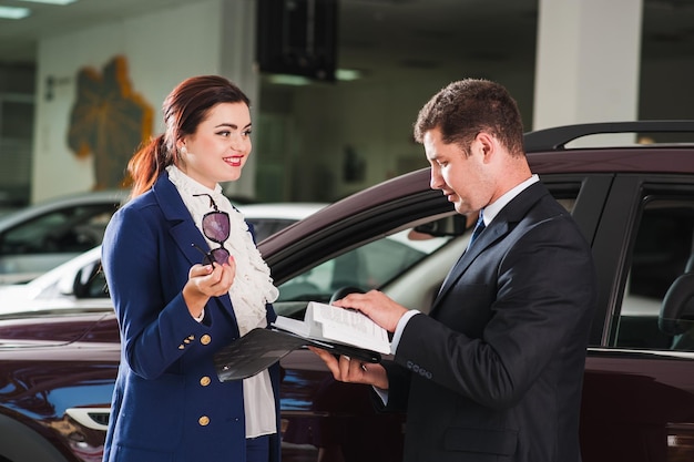 Happy European male client customer woman sitting at the wheel of new carAdvice on buying a car