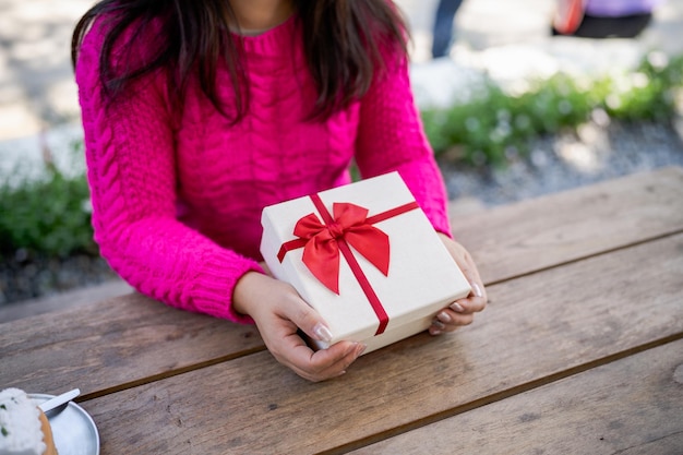 Happy excited asian woman hands holding Christmas gift box cheerful girl packing Xmas present or open box xmas new year birthday gift