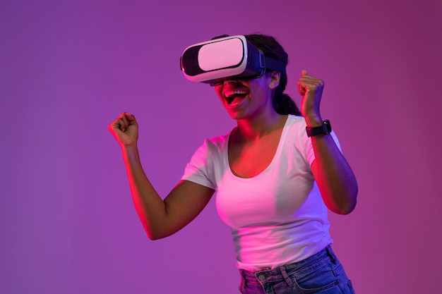 ビデオ ゲームでの勝利を祝う VR ヘッドセットを身に着けている幸せな興奮した黒人女性