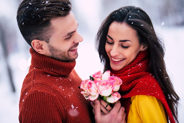 Happy and excited couple in love have a fun, dancing and hugging each other outdoor in winter city park while celebrating st. valentines day