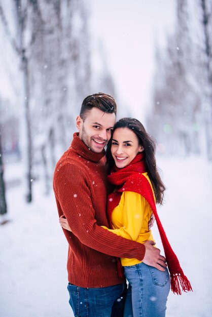 Happy and excited couple in love have a fun, dancing and hugging each other outdoor in winter city park while celebrating St. Valentines day