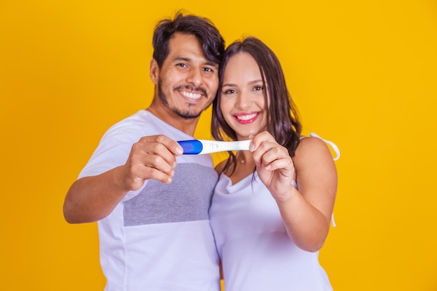 Happy excited couple taking positive pregnancy test and celebrating