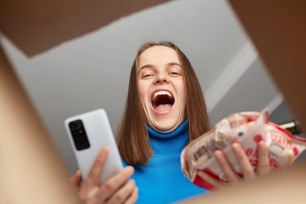 Счастливая взволнованная радостная женщина получает посылку с заказом в интернет-магазине