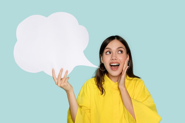青い背景のスピーチバブルを持つ幸せな興奮したラテン語の女性
