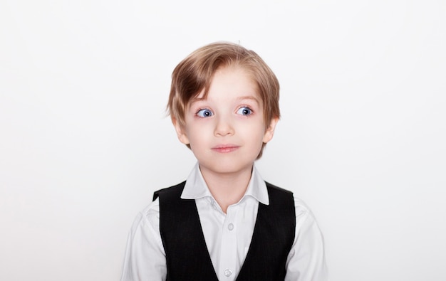 Happy excited little blonde boy in casual clothes is posing isolated on white