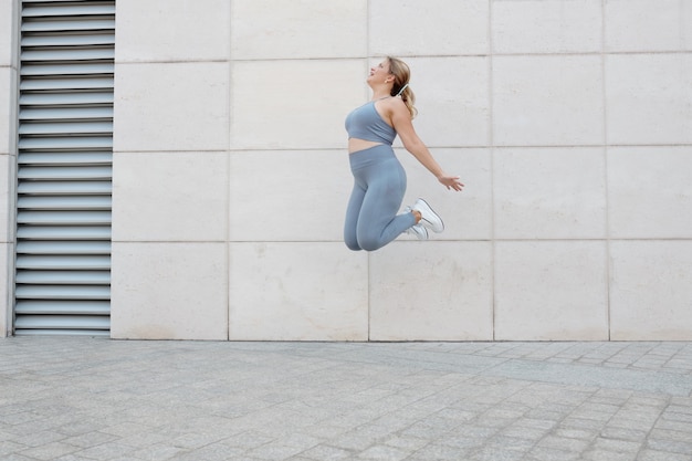 Happy excited plus size young woman jumping high up in the air