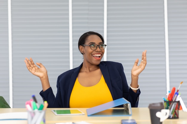 Happy excited successful Beautiful african american businesswoman triumphing in modern office with laptop, success happy pose. Work from home