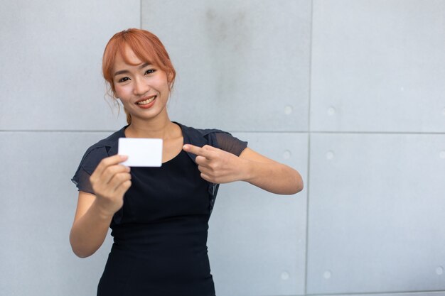 Happy excited successful Beautiful businesswoman holding credit card mock up on hand.
