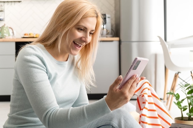 Happy excited woman celebrating success looking at phone screen copy space