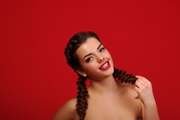 Happy excited woman looking to the side screaming cheerful with wind in the hair on red wall. Beautiful multiracial   Caucasian female mode