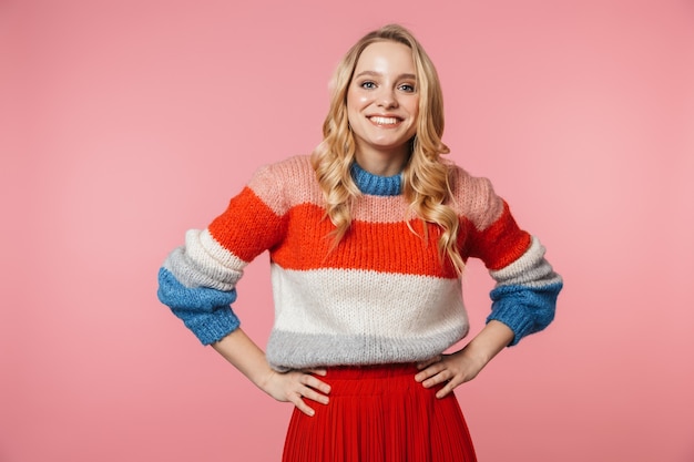 a happy excited young pretty beautiful woman posing isolated over pink wall