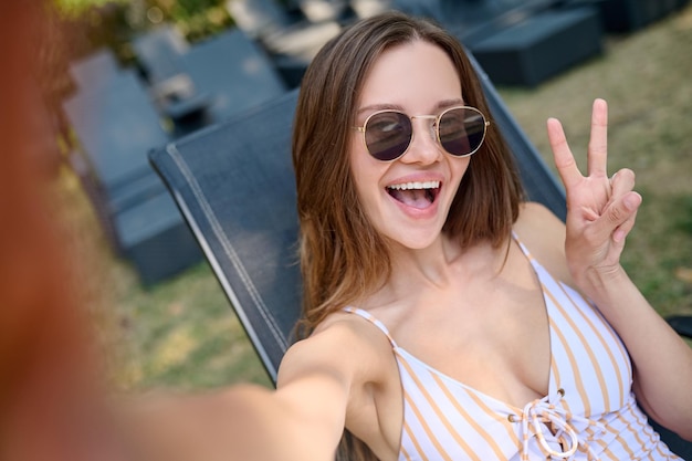 Happy excited young woman making selfie