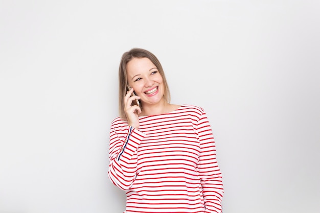 Happy excited young woman talking by mobile phone.