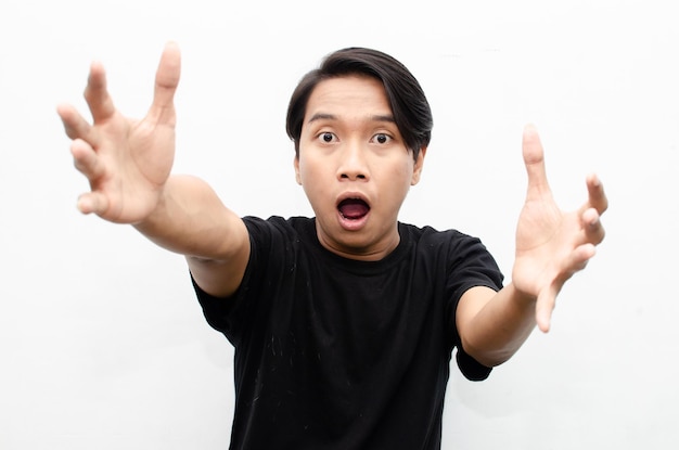 happy expressive asian young man with glasses shocked happily pointing finger and offering something