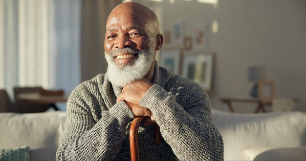happy face and a black man with a cane on the sofa for support medical help and retirement smile house and portrait of a senior african person on the living room couch with a stick for walking