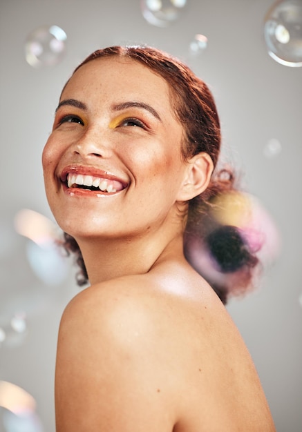 Photo happy face bubbles and woman in studio for skincare cosmetics natural skin glow and dermatology facial makeup health and wellness of aesthetic model person with luxury body product and hope