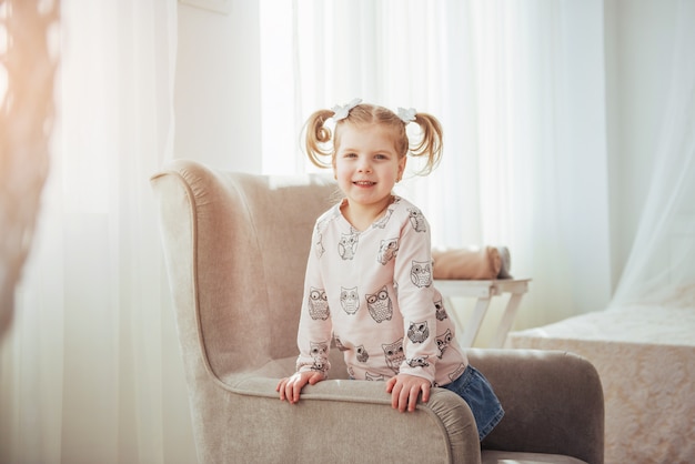 Happy face funny baby girl. In a bright room