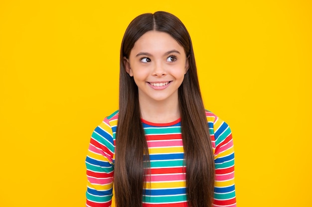 Happy face positive and smiling emotions of teenager girl children studio portrait on yellow background childhood lifestyle concept cute teenage girl face close up